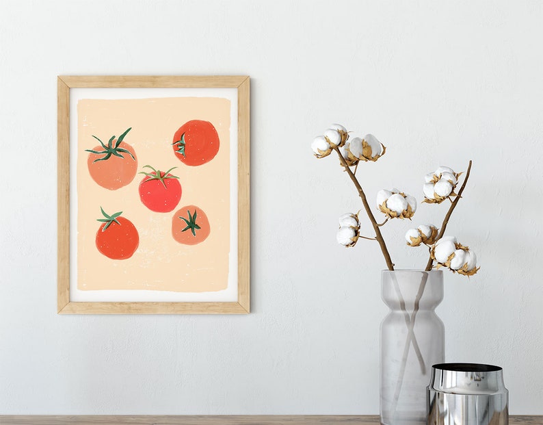 Op de afbeelding: Een ingelijst afdruk van een minimalistische illustratie van rode tomaten op een perzikkleurige achtergrond. De afdruk is in een licht houten frame.