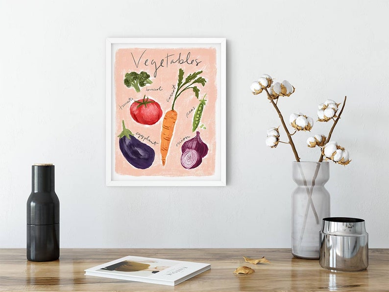 Puede incluir: Una impresi&oacute;n enmarcada en rosa y blanco con la palabra "Vegetales" escrita en letra negra. La impresi&oacute;n presenta ilustraciones de un tomate, una zanahoria, una berenjena, una cebolla, un br&oacute;coli y guisantes.