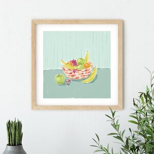May include: A framed illustration of a bowl of fruit. The bowl is red and white striped and contains bananas, apples, and grapes. The bowl is sitting on a light blue surface with a striped pattern.