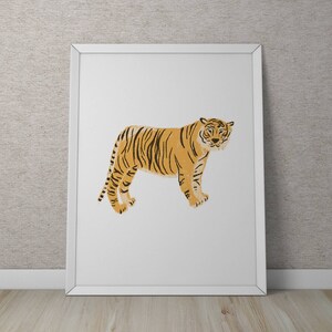 May include: A white framed print featuring a stylized illustration of a tiger in orange and black. The tiger is standing facing forward with its head slightly tilted.