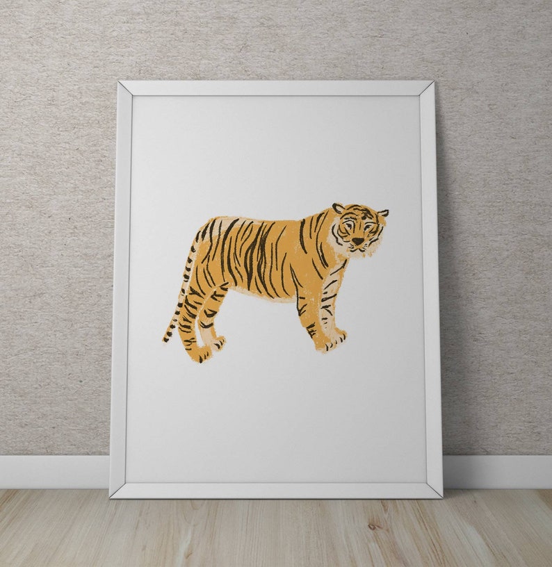 May include: A white framed print featuring a stylized illustration of a tiger in orange and black. The tiger is standing facing forward with its head slightly tilted.