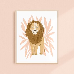 May include: A framed art print featuring a stylized illustration of a lion. The lion has a brown mane and body, with a white face and chest. The background includes pink leaf-like shapes, and the frame is a light beige color.