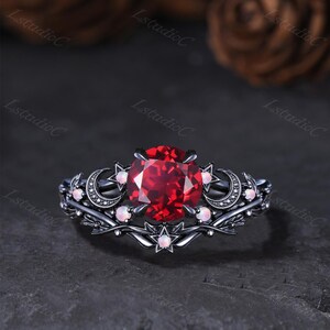 Bague de fiançailles gothique en or noir avec rubis rond céleste, opale, étoile et lune, inspirée par la nature (feuille, brindille, croissant de lune).