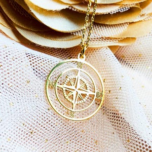 Necklace with compass pendant in gold plated sterling silver .