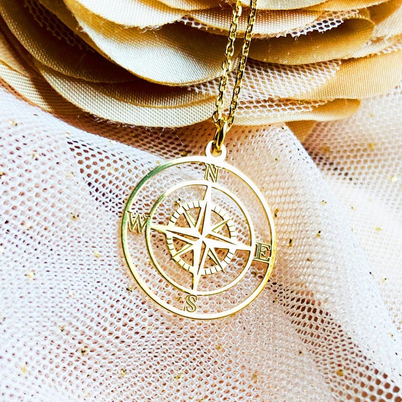 Necklace with compass pendant in gold plated sterling silver .