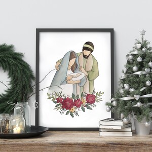 May include: A watercolor painting of the Holy Family. Mary, Joseph, and baby Jesus are depicted in a simple, elegant style. The painting is framed in black and features a floral wreath with red and yellow flowers.