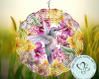 Puede incluir: Un molinillo de viento de metal colorido con un colibrí y un diseño floral. El molinillo tiene una forma circular con múltiples capas de metal que giran con el viento. El colibrí está representado en vuelo con las alas extendidas. El diseño floral presenta flores rosas, amarillas y moradas. El molinillo de viento está suspendido de un gancho. El texto "The Little Love Art Co. Printable Digital Paper & Graphics" está impreso en la parte inferior del molinillo.