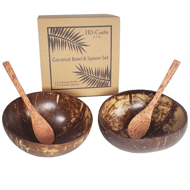 Two coconut bowls and spoons in front of a brown box