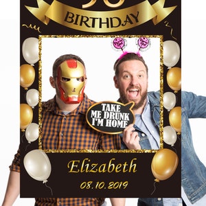 May include: A black and gold photo booth prop with a gold ribbon that says "50th Birthday". The photo booth prop has a frame with a gold glitter border and balloons. The frame has a speech bubble that says "Take me drunk I'm home". The photo booth prop also has a name and date that says "Elizabeth 08.10.2019".