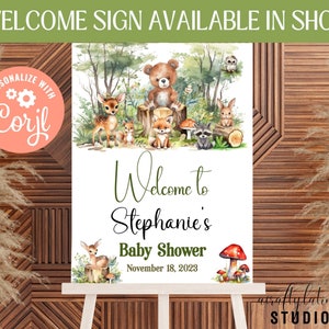 May include: A welcome sign for a baby shower with a woodland theme. The sign features a watercolour illustration of a bear, deer, fox, raccoon and owl in a forest setting. The text on the sign reads "Welcome to Stephanie's Baby Shower November 18, 2023".