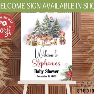 May include: A printable welcome sign for a baby shower with a winter woodland theme. The sign features a snowy forest scene with deer, a bear, and a squirrel. The text reads "Welcome to Stephanie's Baby Shower December 9, 2023".