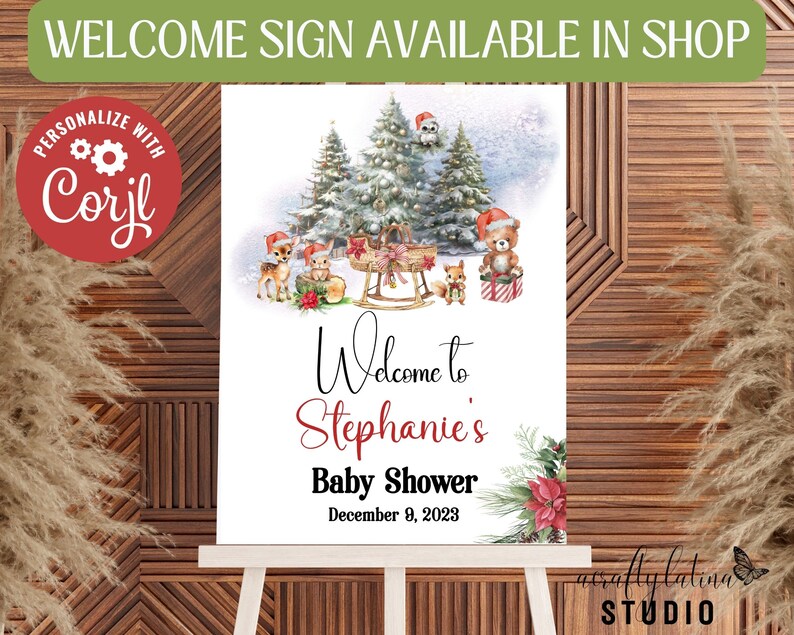 May include: A printable welcome sign for a baby shower with a winter woodland theme. The sign features a snowy forest scene with deer, a bear, and a squirrel. The text reads "Welcome to Stephanie's Baby Shower December 9, 2023".