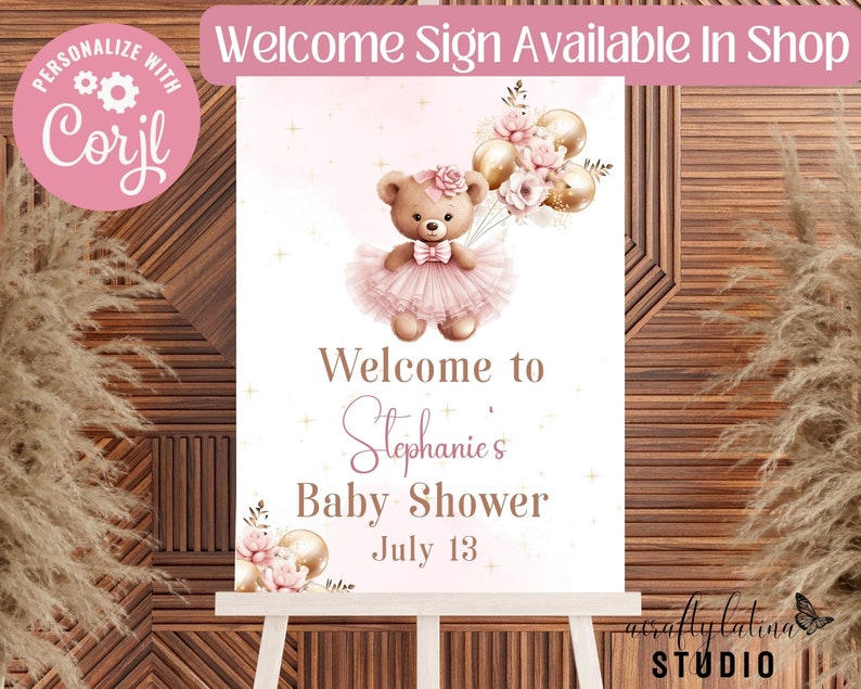 Peut inclure: Un panneau de bienvenue rectangulaire pour une f&ecirc;te pr&eacute;natale repr&eacute;sentant un ours en peluche marron portant un tutu et un n&oelig;ud roses, tenant des ballons dor&eacute;s et roses. Le texte indique Welcome to Stephanie's Baby Shower July 13, avec des &eacute;toiles dor&eacute;es.