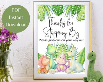May include: A printable sign with a white background and green leaves. The sign says "Thanks for stopping by. Please grab one on your way out." There are four cartoon dinosaurs at the bottom of the sign. The dinosaurs are green, blue, pink, and orange.