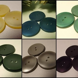May include: Assortment of ten plastic buttons in various colors, including green, blue, gray, and beige. The buttons have two holes and are arranged in three rows.