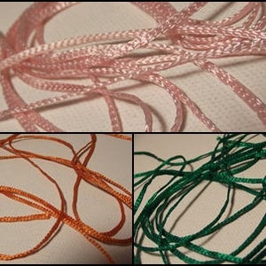 Peut inclure: Gros plan sur trois sections de cordon coloré. La section supérieure présente un cordon rose, la section inférieure gauche un cordon orange et la section inférieure droite un cordon vert. Les cordons sont entrelacés et semblent être faits d'un matériau tissé.