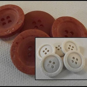 Könnte beinhalten: Vier braune Knöpfe mit jeweils vier Löchern und vier weiße Knöpfe mit jeweils vier Löchern.