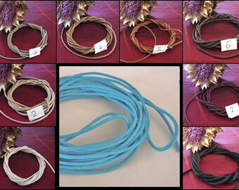 May include: A selection of coloured cords, including light blue, brown, and grey, displayed in circular arrangements. Each bundle is labelled with a number on a small white tag. The cords vary in thickness and texture, suitable for crafts or jewellery making.