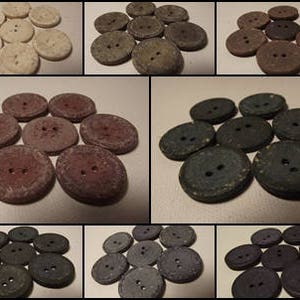 May include: A collection of round buttons in a variety of colours. The buttons are made from a textured material and have two holes for sewing. Colours include cream, grey, brown, and dark blue.