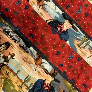 May include: A fabric featuring a Western theme with repeating diagonal panels. One panel displays cowboys, cacti, and desert landscapes, while the alternating red panel is patterned with small brown cowboy hats, lassos, and gold stars.