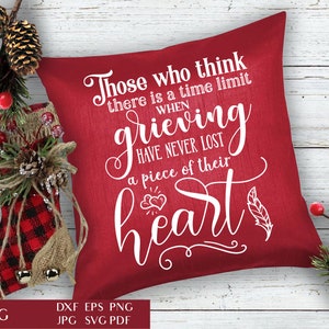 May include: Red decorative pillow with white text: "Those who think there is a time limit when grieving have never lost a piece of their heart." The pillow is surrounded by Christmas decorations, including a stocking and pinecones.