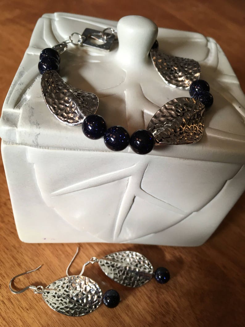 Unusual navy blue goldstone beads and pewter leaves on 7 bracelet amd earrings to match.