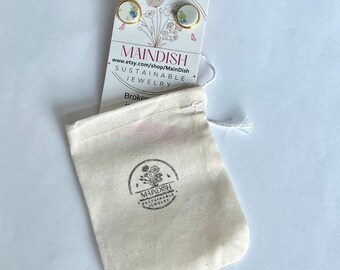 Pendientes de poste hechos a mano a partir de un plato roto engastado en un bisel circular con diseño floral.