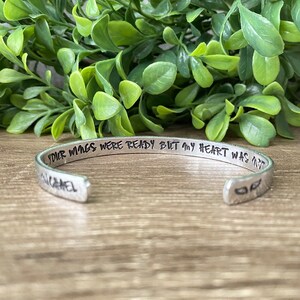 May include: Silver bracelet with the inscription "Your wings were ready but my heart was not". The bracelet has a small angel wing design on the side.