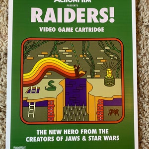 May include: A green poster with the text "ActionFilm Presents Raiders! Video Game Cartridge" in white. The poster features a retro-style video game cartridge illustration with a character swinging on a vine, a snake, a ladder, spikes, and a spider.