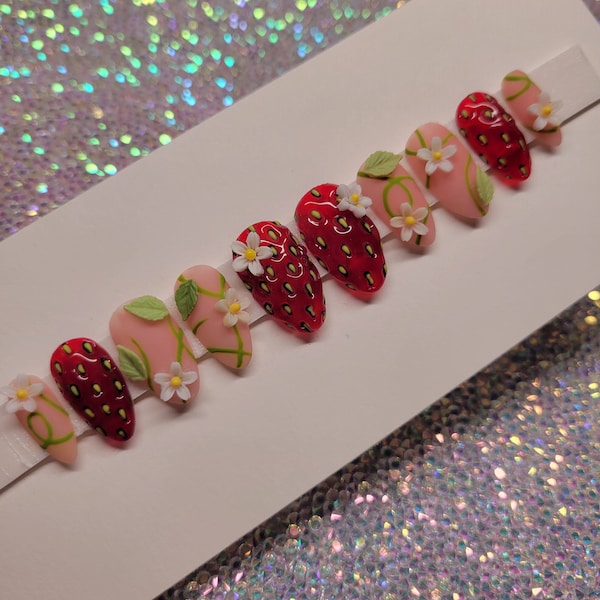 Fresas jugosas en la vid prensadas en las uñas