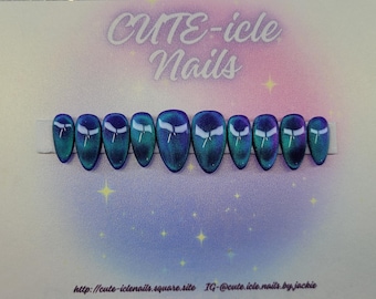 May include: A set of ten oval-shaped false nails. Each nail has a gradient design of teal and blue with a white bow-tie design. The background is a gradient of pink and blue with the text "CUTE-icle Nails".