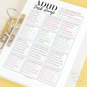 May include: A white paper with a printed ADHD task list, held in a gold binder. The task list includes sections for calls, errands, emails, and appointments. The text "ADHD task dump" is at the top, with the date "Monday, September 23rd."