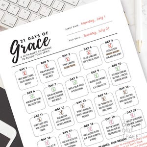 May include: A faith-filled challenge to renew your spirit, titled "21 Days of Grace", printed on white paper. The planner includes daily prompts for reflection and prayer, with start and end dates. The title is in a stylish script font.