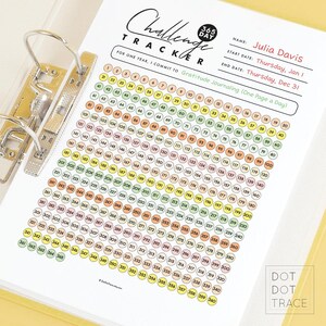 May include: A 365-day challenge tracker printed on white paper, held in a yellow binder. The tracker includes a grid with numbered circles for daily journaling, with the text "Challenge Tracker" at the top.