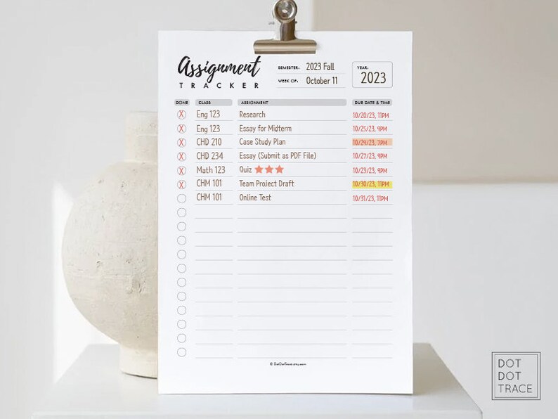 May include: A white printable assignment tracker with a clip at the top. The tracker is labelled "Assignment Tracker" and has a section for class, assignment, due date and time. The tracker is for the Fall 2023 semester and the week of 11th October.