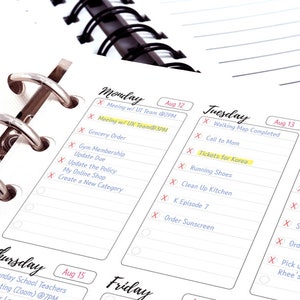 May include: A weekly planner with a black and silver binder. The planner has a white background with black lines and includes the days of the week: Monday, Tuesday, Wednesday, Thursday, and Friday. Each day has a date and a list of tasks to be completed. Some tasks are highlighted in yellow.