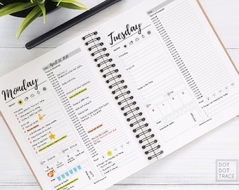 May include: A close-up of a daily planner with a spiral binding. The planner has a white background with black text and icons. The planner is open to the pages for Monday and Tuesday. The pages are filled with handwritten notes and checkmarks. The planner is labeled "DOT DOT TRACE" at the bottom right corner.