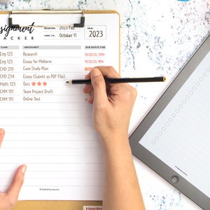 May include: A white assignment tracker with a checklist and space to write in class names, assignments, due dates, and times. The tracker is on a clipboard with a black pencil on top of it. The words "Assignment Tracker" are written in black at the top of the page.