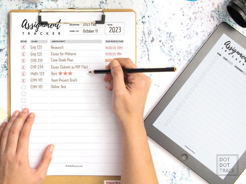 May include: A white assignment tracker with a checklist and space to write in class names, assignments, due dates, and times. The tracker is on a clipboard with a black pencil on top of it. The words "Assignment Tracker" are written in black at the top of the page.