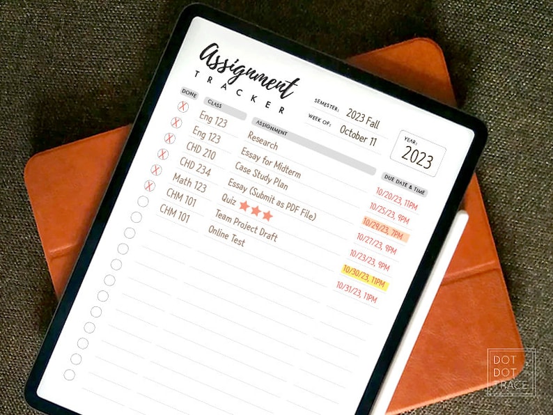 May include: A digital planner on a tablet screen with a white stylus. The planner is titled "Assignment Tracker" and includes a list of classes, assignments, due dates, and times. The semester is 2023 Fall and the week is October 11. The year is 2023.