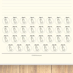 May include: A printable sheet with 31 circles, each containing a drawing of two hands clasped in prayer. The circles are labeled with the numbers 1 through 31, indicating days of the month. The text "DOT DOT TRACE" appears at the bottom of the sheet.
