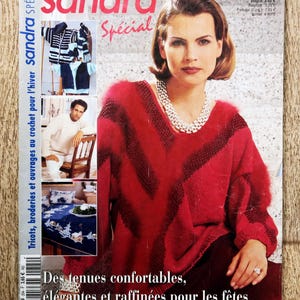 May include: A magazine cover with a woman in a red chevron-patterned sweater and a pearl necklace. The magazine is titled "sandra Spécial" and includes French text. Other images show knitwear and a man in a white sweater.