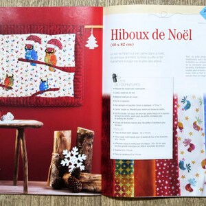 Op de afbeelding: Een boek met een rode kaft en een kleurrijk quiltontwerp van uilen op een tak. Het boek is open op een pagina met instructies voor het maken van de quilt. De tekst op de pagina luidt "Hiboux de No&euml;l (60 x 82 cm)".