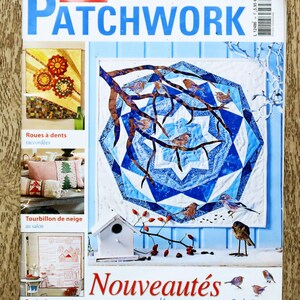 Può includere: La copertina di una rivista intitolata "Sabrina Patchwork" presenta una trapunta patchwork blu e bianca con un disegno di uccelli e rami. La copertina mostra anche immagini di altri progetti patchwork, tra cui cuscini e oggetti decorativi. Il testo "Nouveautés pour l'automne & hiver" è anch'esso visibile.