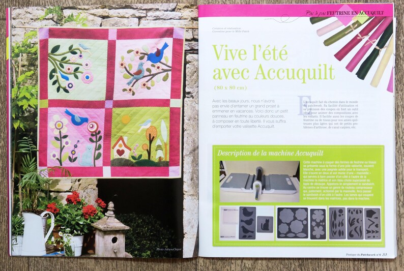 May include: A magazine page featuring a quilt with a summer theme. The quilt is made up of four squares with different designs, including birds, flowers, and houses. The magazine page also includes text in French about the quilt and the Accuquilt machine.