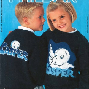 以下が含まれることがあります： カスペル・ザ・フレンドリー・ゴーストのグラフィックが描かれた、青と黒のニットセーターを着た子供2人。セーターは青で、白と水色のアクセントが付けられている。子供たちはストライプのパンツとジーンズを履いている。