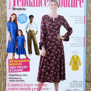 Peut inclure: Couverture du magazine "Tendances Couture" de Simplicity, avec une femme en robe fleurie. La couverture comprend des images de robes et d'autres vêtements, avec du texte en français promouvant des patrons de couture.