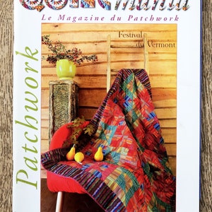 Op de afbeelding: Een tijdschriftcover voor Quiltmania, een patchworkmagazine. De cover toont een kleurrijk quilt dat over een rode stoel met pompoenen voor een houten muur is gedrapeerd. De tekst op de cover luidt "Quiltmania, Le Magazine du Patchwork, Festival du Vermont, Patchwork, Bimestriel - Septembre/Octobre 2004 - N°43".