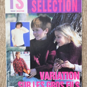 Può includere: Una copertina di rivista con il titolo "TRICOT SELECTION" in rosa e bianco e il testo "VARIATION SUR LES GROS FILS" in rosa. La copertina presenta tre foto di persone che indossano maglioni e giacche di lana.