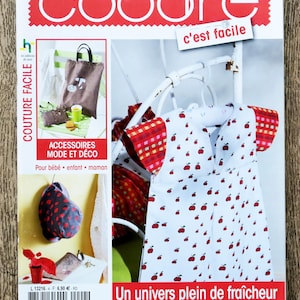 Könnte beinhalten: Ein Magazin-Cover mit dem Wort "coudre" in Rot und dem Text "c'est facile". Das Cover zeigt Bilder von Nähprojekten, darunter eine Tragetasche, Accessoires und eine weiße Schürze mit roten Apfelmustern. Der Text "Un univers plein de fraîcheur pour le printemps" ist ebenfalls sichtbar.